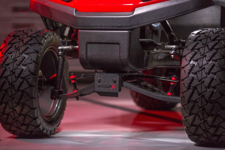 Red golf cart with a black lift kit parked on concrete